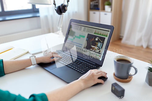 Image of woman with video editor program on laptop at home