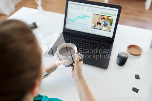 Image of woman with video editor program on laptop at home