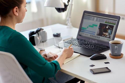 Image of woman with video editor program on laptop at home