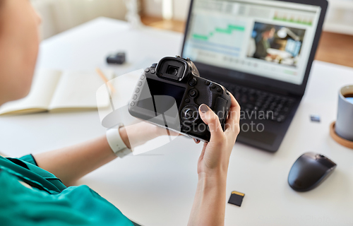 Image of woman with camera and video editor on laptop