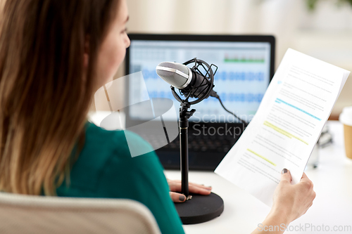 Image of woman with microphone recording podcast at studio