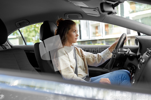 Image of woman or female driver driving car in city