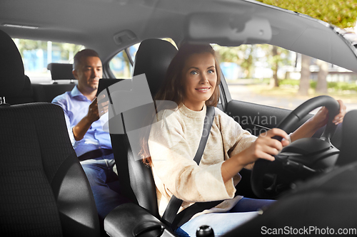 Image of female driver driving car with male passenger