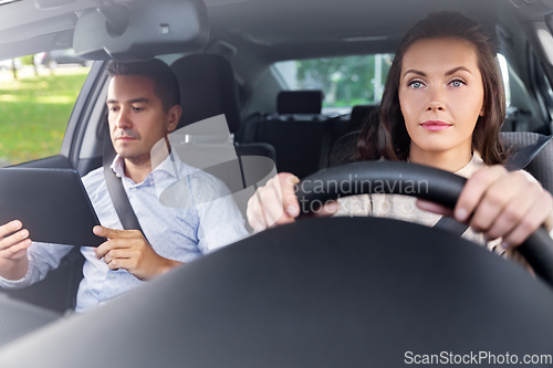 Image of woman and driving school instructor in car