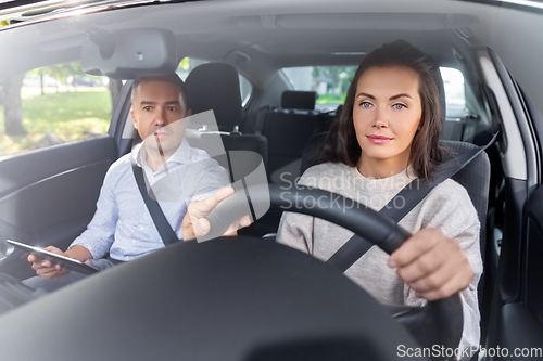 Image of woman and driving school instructor in car