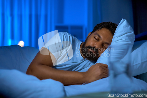 Image of indian man sleeping in bed at home at night