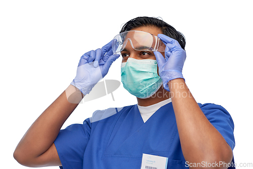 Image of indian male doctor in blue uniform and mask