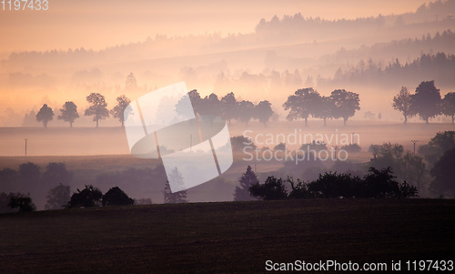 Image of Autumn foggy and misty sunrise landscape
