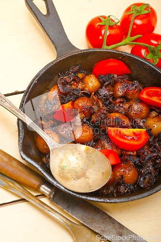 Image of Baby cuttle fish roasted on iron skillet