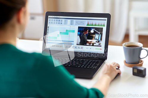 Image of woman with video editor program on laptop at home