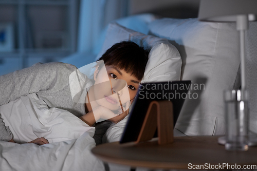 Image of asian woman with tablet pc in bed at home at night