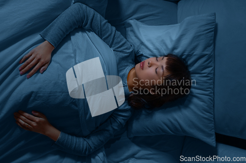 Image of asian woman sleeping in bed at home at night