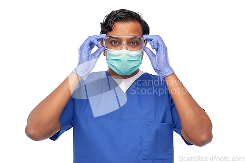 Image of indian male doctor in blue uniform and mask