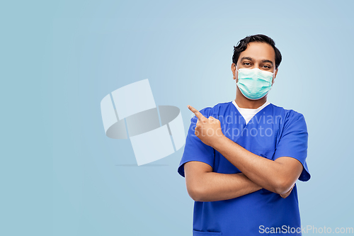 Image of indian male doctor in blue uniform and mask