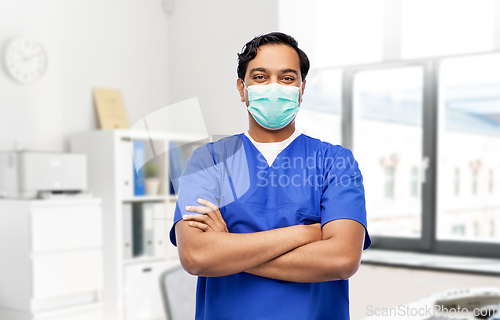 Image of indian male doctor in blue uniform and mask