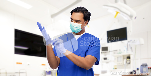 Image of indian male doctor in uniform, mask and gloves