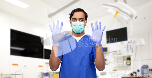 Image of indian male doctor in uniform, mask and gloves