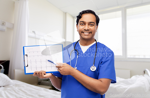 Image of smiling male doctor with cardiogram on clipboard