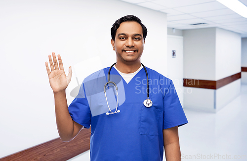 Image of doctor or male nurse with stethoscope waving hand