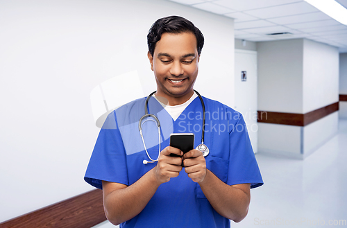 Image of smiling doctor or male nurse using smartphone