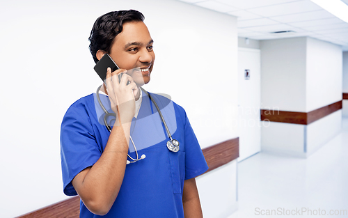 Image of smiling doctor or male nurse calling on smartphone