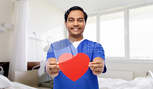 Image of smiling male doctor with red heart on clipboard