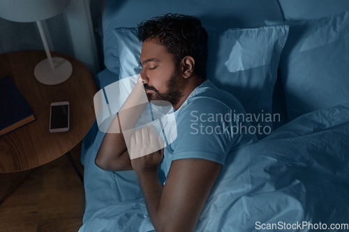 Image of indian man sleeping in bed at home at night