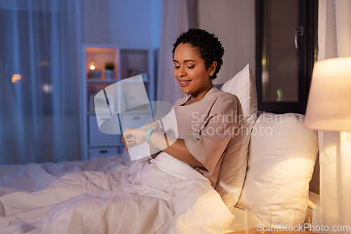 Image of woman with health tracker in bed at night