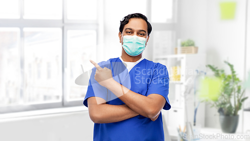 Image of indian male doctor in blue uniform and mask