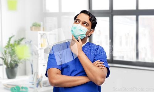 Image of indian male doctor in blue uniform and mask