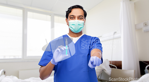 Image of indian male doctor in mask with vaccine in syringe