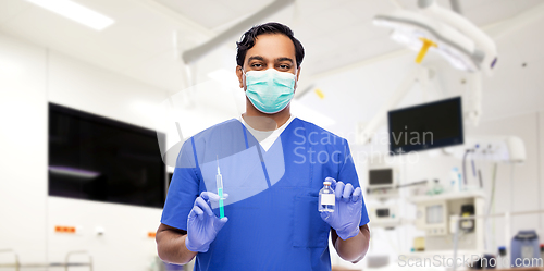 Image of indian doctor in mask with syringe and medicine
