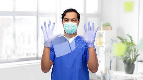 Image of indian male doctor in uniform, mask and gloves