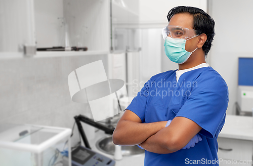 Image of indian male doctor in blue uniform and mask