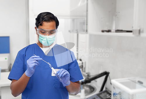 Image of male doctor in mask with cotton swab and test tube