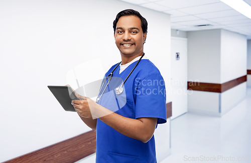 Image of smiling doctor or male nurse using tablet computer