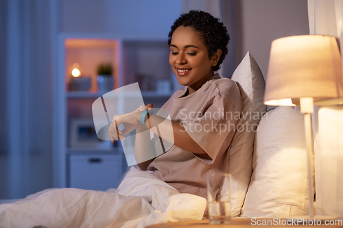 Image of woman with health tracker in bed at night