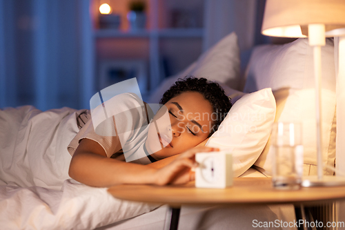 Image of woman awaking because of alarm clock at night