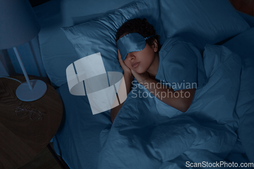 Image of african woman sleeping in bed at home at night