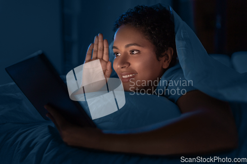 Image of woman with tablet pc having video call in bed