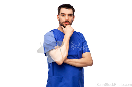 Image of thinking doctor or male nurse in blue uniform