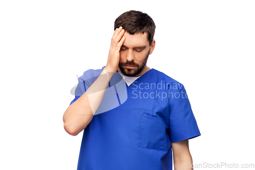 Image of stressed doctor or male nurse in blue uniform