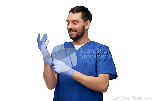 Image of doctor or male nurse putting medical gloves on