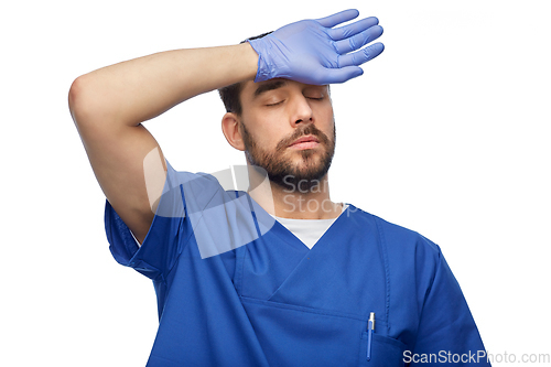 Image of tired doctor or male nurse in blue uniform