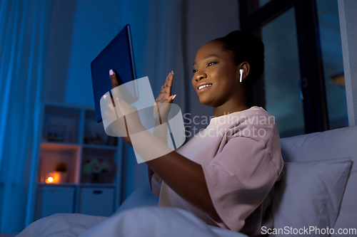 Image of woman with tablet pc having video call at night