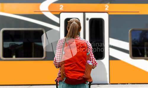 Image of young woman with backpack traveling over train