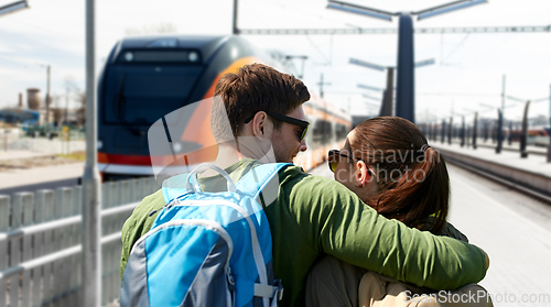 Image of happy couple with backpacks traveling by train