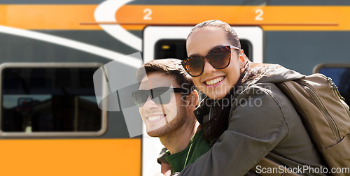 Image of happy couple with backpacks traveling by train