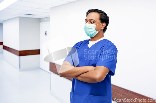 Image of indian male doctor in blue uniform and mask