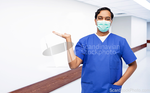 Image of indian male doctor in blue uniform and mask